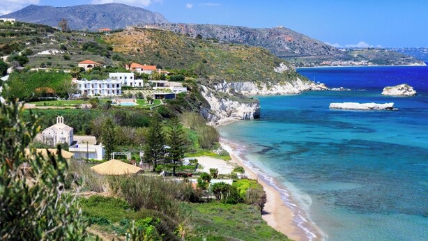 A coastal property with a beach, a mountain in the background, and a clear blue sea. - Titan Villas - Villa Kronos (Chania)