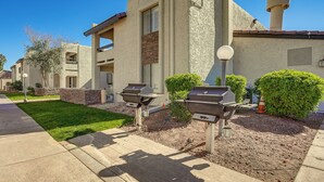 Un immeuble résidentiel avec une façade en pierre, une cheminée et deux barbecues dans le jardin avant.