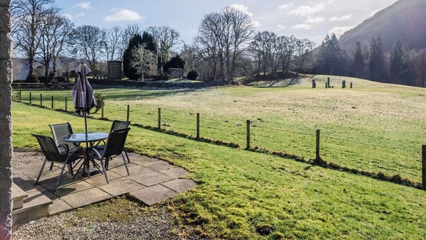 A patio with outdoor seating, a fenced field, and a mountain backdrop. - Stunning private villa for 8 people with WIFI, TV, terrace and panoramic view (Invermoriston)
