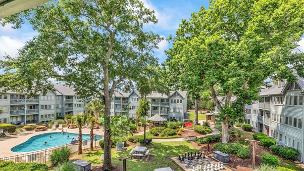 A courtyard with a swimming pool, outdoor seating, and a chess table. - Myrtle Beach Resort 6306 (Myrtle Beach)