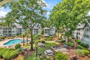 A courtyard with a swimming pool, outdoor seating, and a chess table. - Myrtle Beach Resort 6306 (Myrtle Beach)
