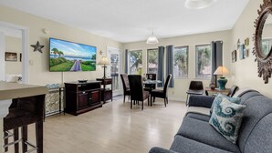 A living room with a TV, dining table, chairs, and a sofa. - Myrtle Beach Resort 6306 (Myrtle Beach)