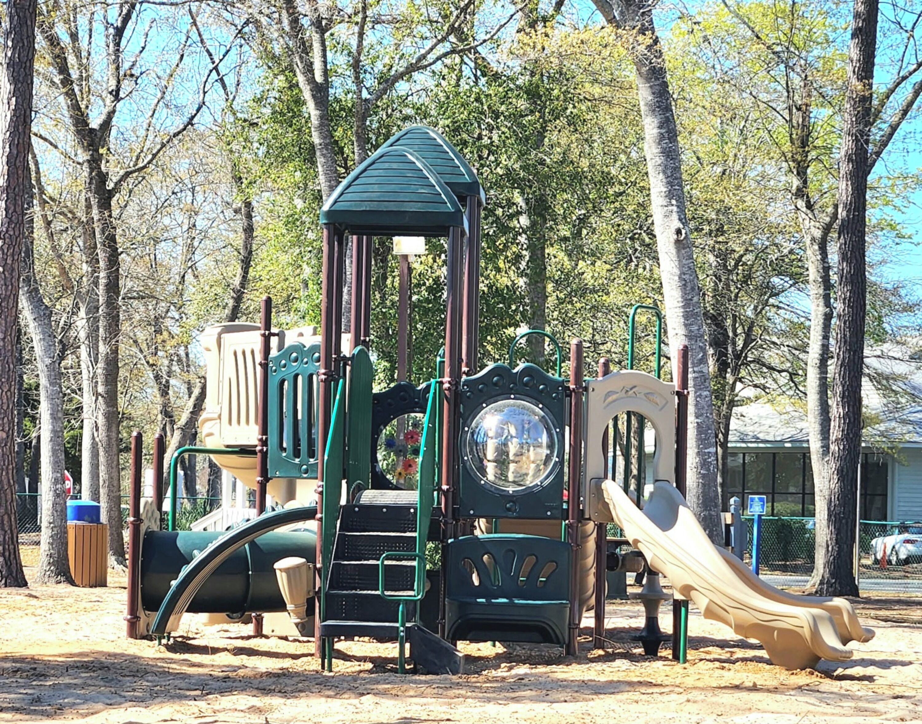 A playground with a climbing structure, slides, and swings.