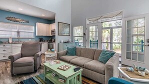 A living room with a sofa, armchair, coffee table, and a view of the outside. - 34 Davis Love Drive (Fripp Island)