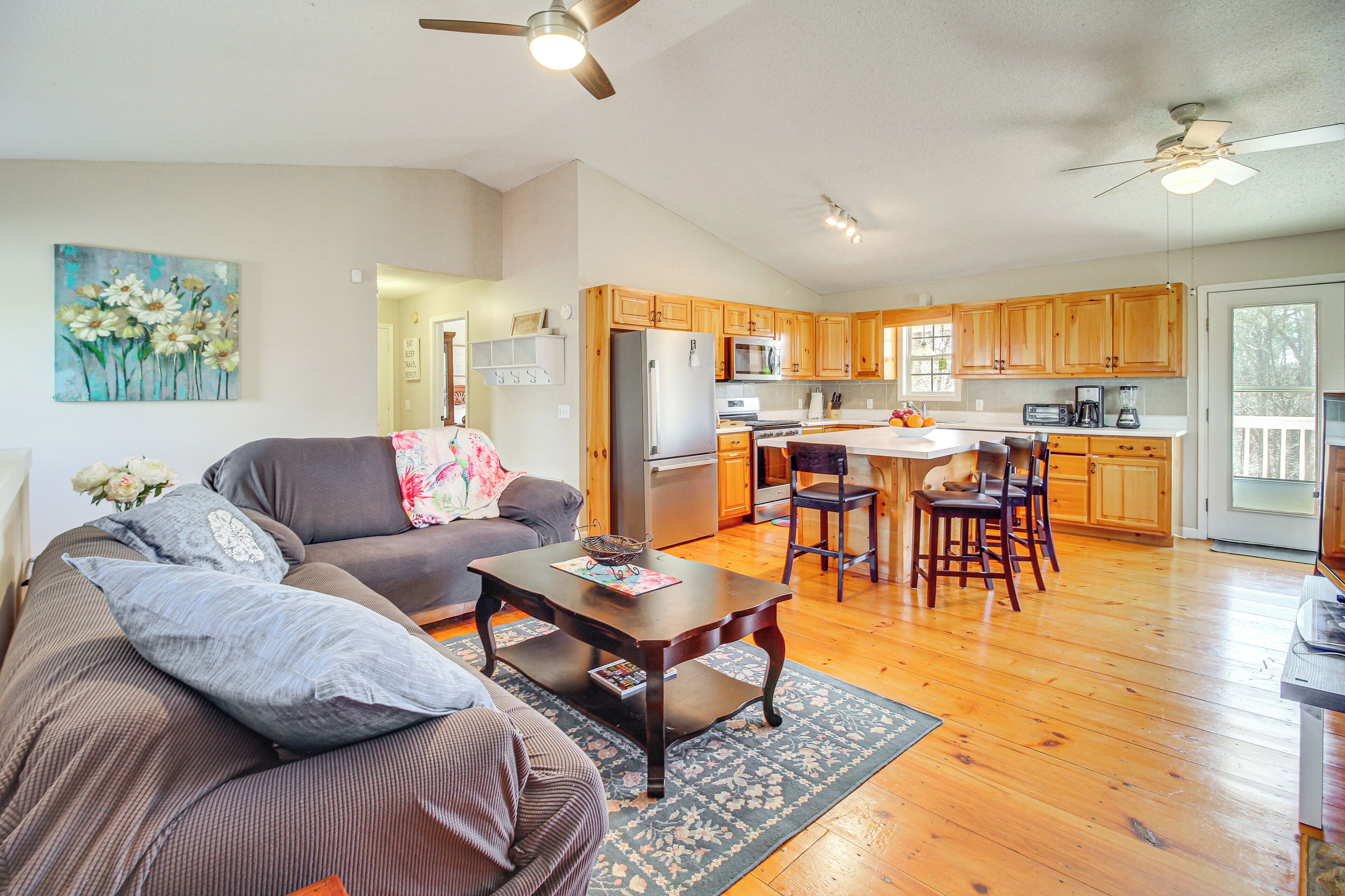 A spacious living area with a sofa, coffee table, and a dining area with chairs.