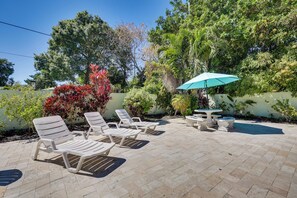 A patio with white lounge chairs, a table, and a blue umbrella. - 5 Mi to Beaches! Family Home in Fort Lauderdale (Fort Lauderdale)