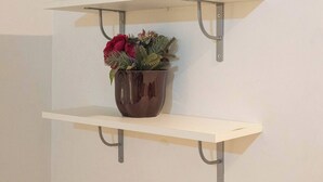 A wall-mounted shelf with a potted plant. - Rooms Steps from Colosseum by Welcome In (Rome)