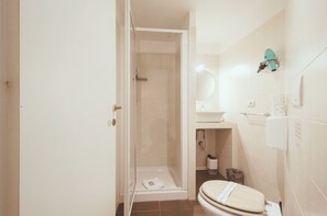 A bathroom with a shower, toilet, sink, and a towel rack. - Rooms Steps from Colosseum by Welcome In (Rome)