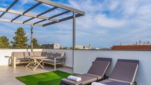 A rooftop terrace with a pergola, two lounge chairs, a sofa, and a small table. - Casino & Mall Luxury Penthouse Suite (Limassol)