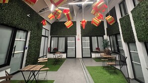 A modern office space with hanging gift boxes, green artificial grass, and a clean, contemporary design. - Sorolla Urban Suites (Valencia)