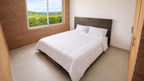 Une chambre à coucher avec un lit, une fenêtre et une vue sur la verdure.