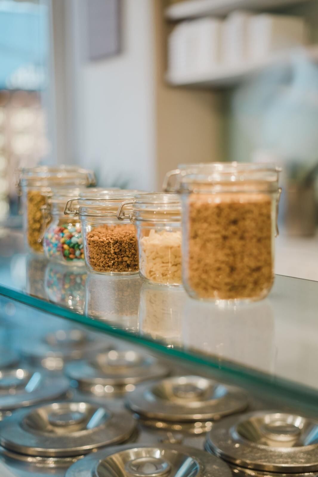 A glass display case with jars containing various grains and seeds.