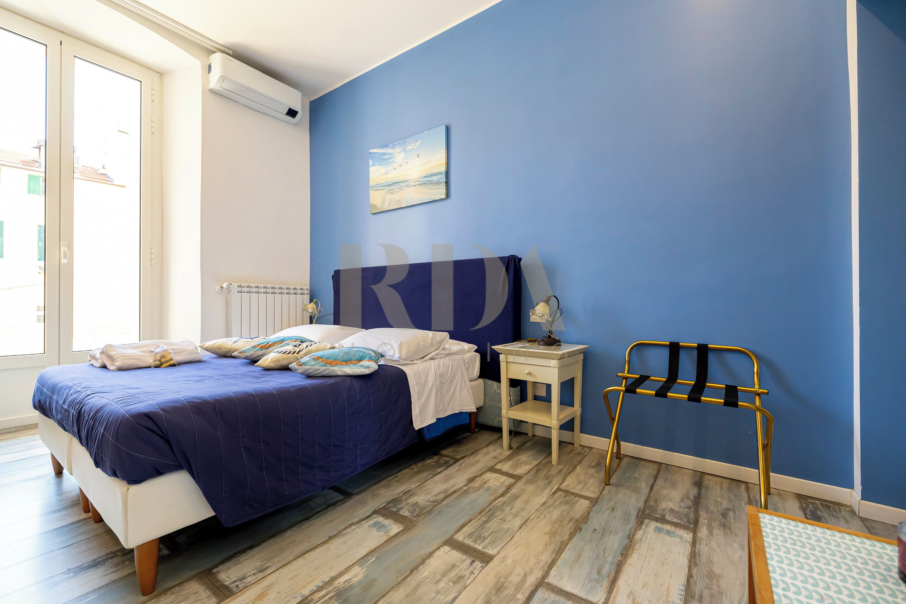 A bedroom with a bed, bedside table, and a chair.