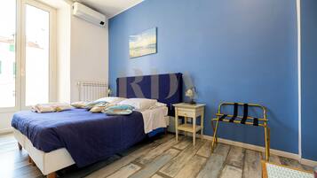 A bedroom with a bed, bedside table, and a chair.