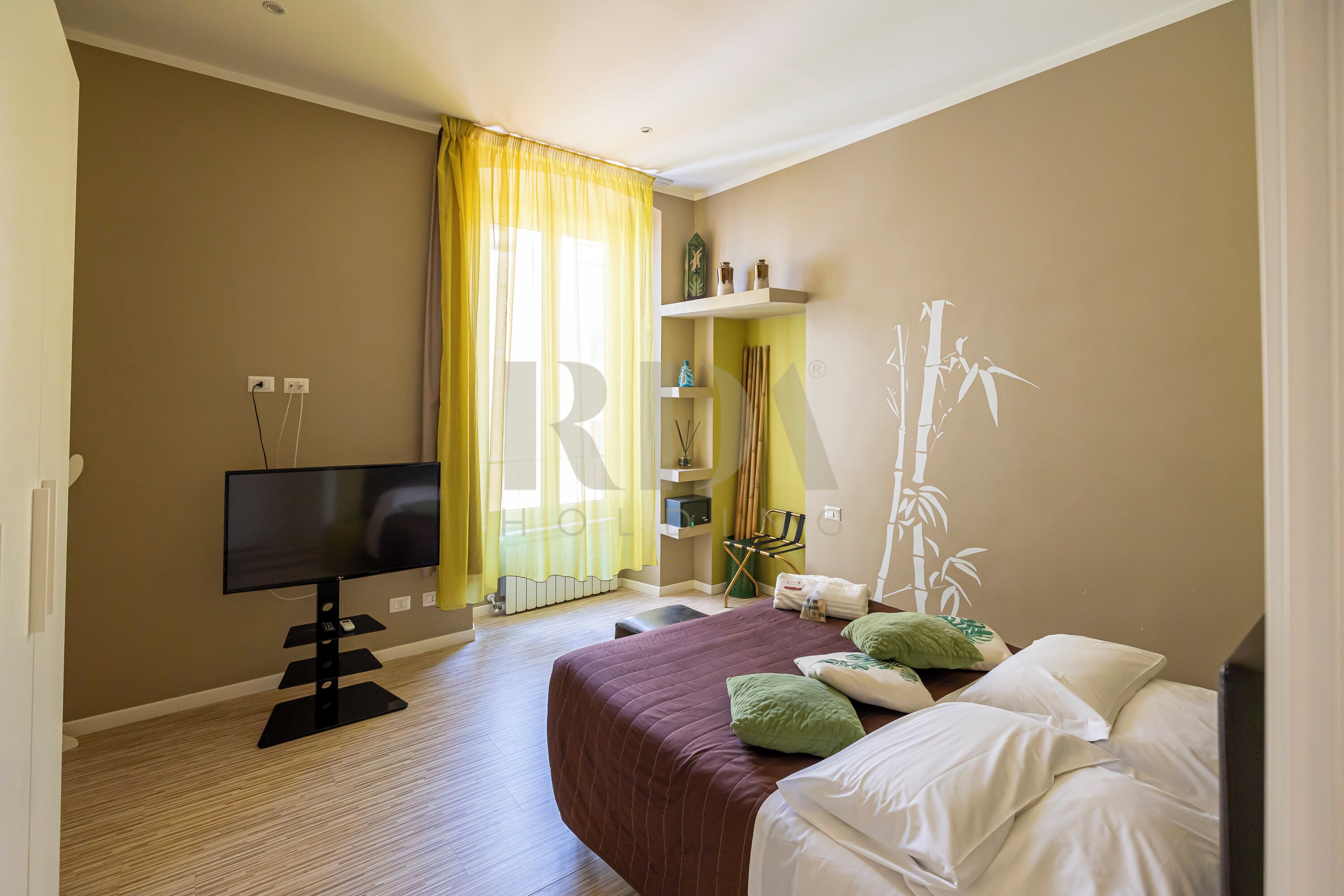 Une chambre d’hôtel avec un lit, une télévision, un bureau et une chaise.