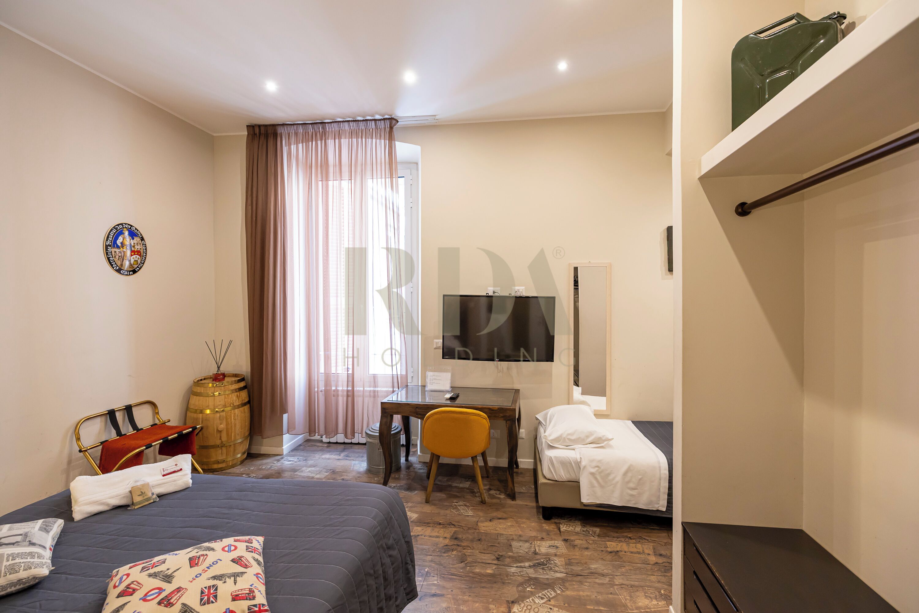 Ein Hotelzimmer mit Bett, Schreibtisch, Stuhl, Fernseher und Kleiderschrank.