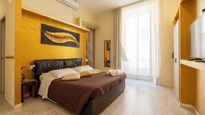 A bedroom with a bed, bedside tables, a mirror, and a painting on the wall. - SanremoInn Exclusive rooms (Sanremo)