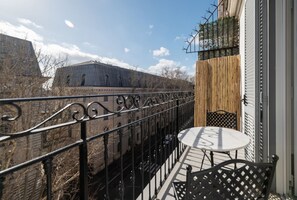 A balcony with a wrought iron railing, a small round table, and a chair. - Castro Pretorio 25 - FHTR (Roma)