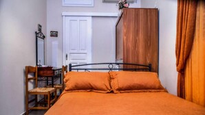 Una camera da letto con un letto, una sedia, una scrivania e un armadio.