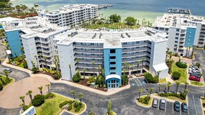 A multi-story hotel with a central courtyard, parking, and a view of the ocean. - Destin West Gulfside V509 Condo (Fort Walton Beach)