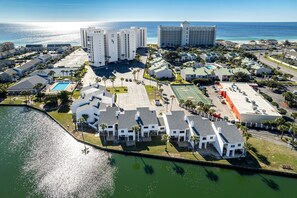 An aerial view of a coastal resort with multiple buildings, a marina, and a large pool. - Shoreline Towers 1111 3 Bedroom Condo (Destin)