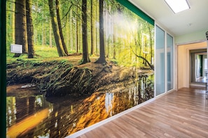 A hallway with a large forest mural on one wall and wooden flooring. - Apartment 'Ferienwohnung Zum Schwarzwaldfrosch' with Balcony and Wi-Fi (Freudenstadt)