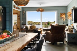 A dining area with a wooden table, chairs, and a view of the outdoors.