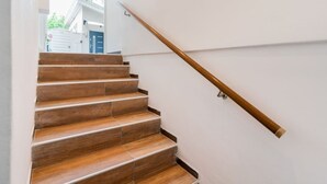 Un escalier en bois avec une rampe et des murs blancs.