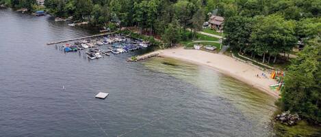 Una propiedad frente al lago con muelle, barcos y playa.