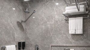 Une salle de bain moderne avec une douche en marbre, des toilettes et un bidet.