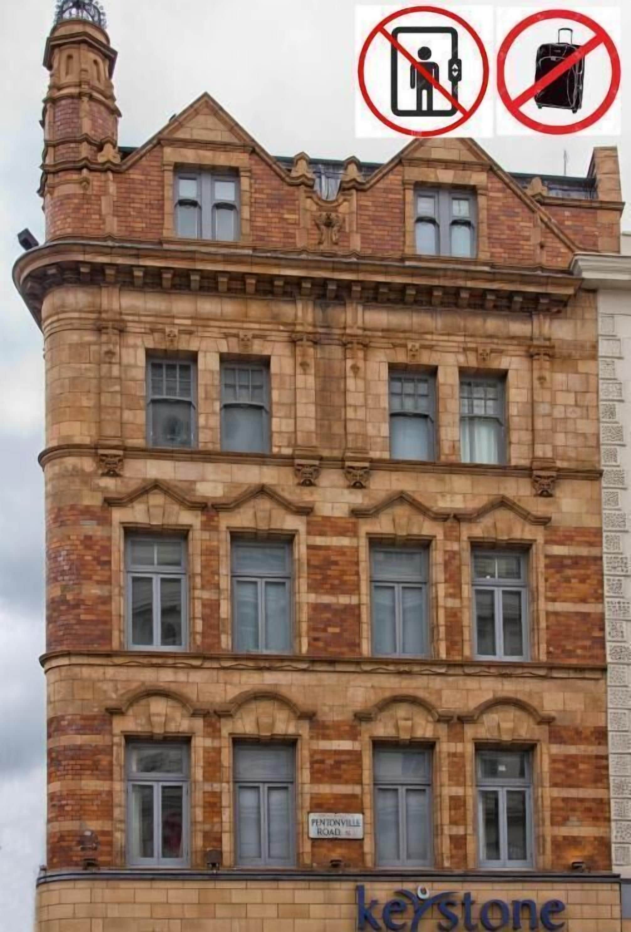 A historic building with a corner entrance, multiple windows, and a sign for 'Kentonville Road'.