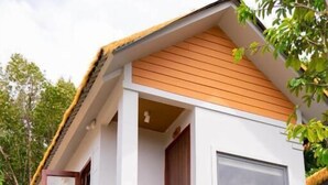 A two-story house with a wooden balcony, a large window, and a staircase leading to the upper floor. - FOREST HOME PHU QUOC (Phu Quoc)