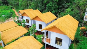 A cluster of white buildings with thatched roofs, surrounded by dense greenery. - FOREST HOME PHU QUOC (Phu Quoc)