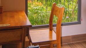 A room with a large window, a wooden table, and a chair. - FOREST HOME PHU QUOC (Phu Quoc)