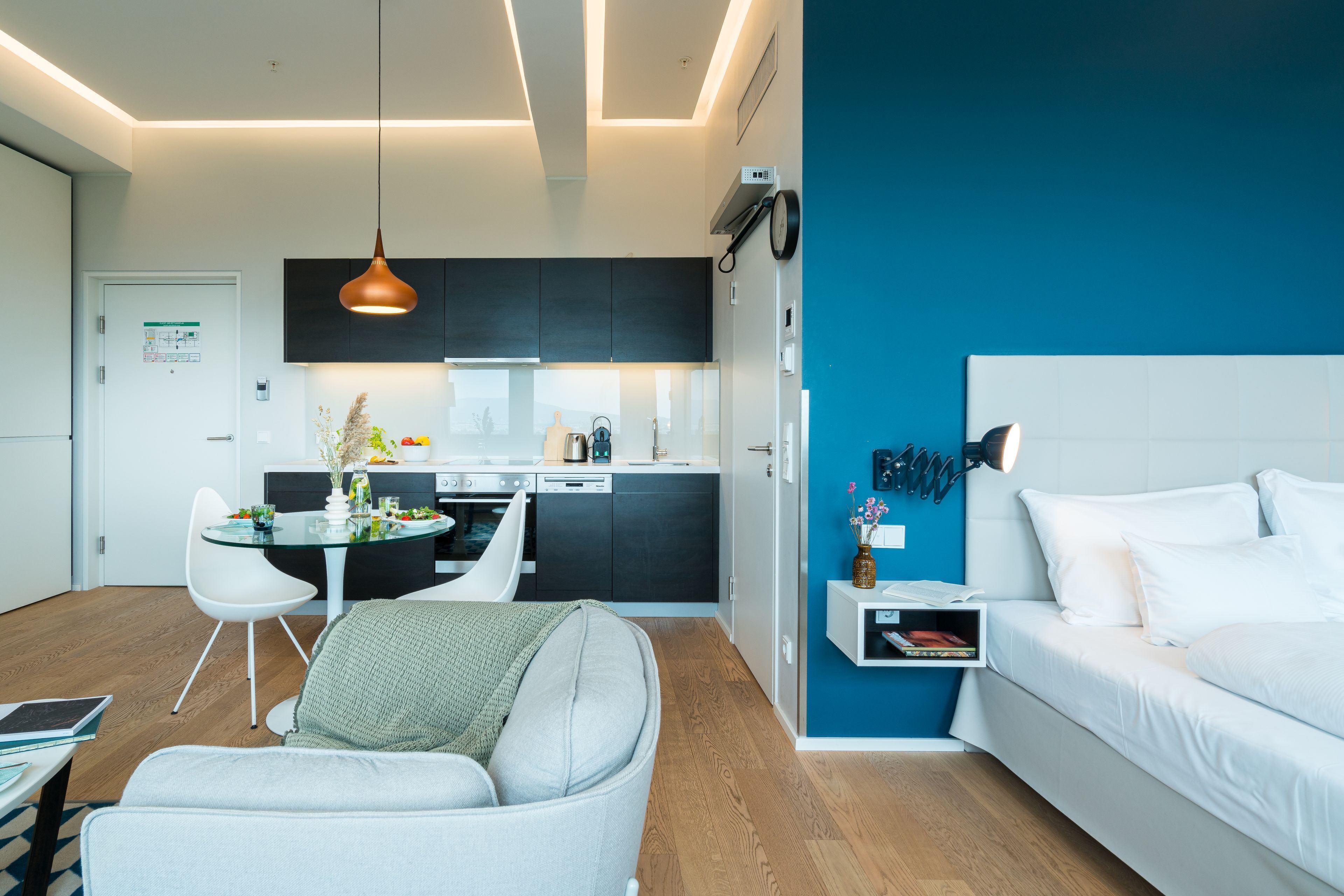 Un appartement moderne comprenant une cuisine, un coin repas et une chambre.