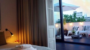 A hotel room with a bed, a nightstand, a lamp, and a view of the outdoor balcony area. - Oporto Private Room/TERRACE (Porto)