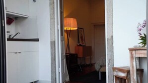 A doorway leading to a room with a lamp, a small table, and a potted plant. - Oporto Private Room/TERRACE (Porto)