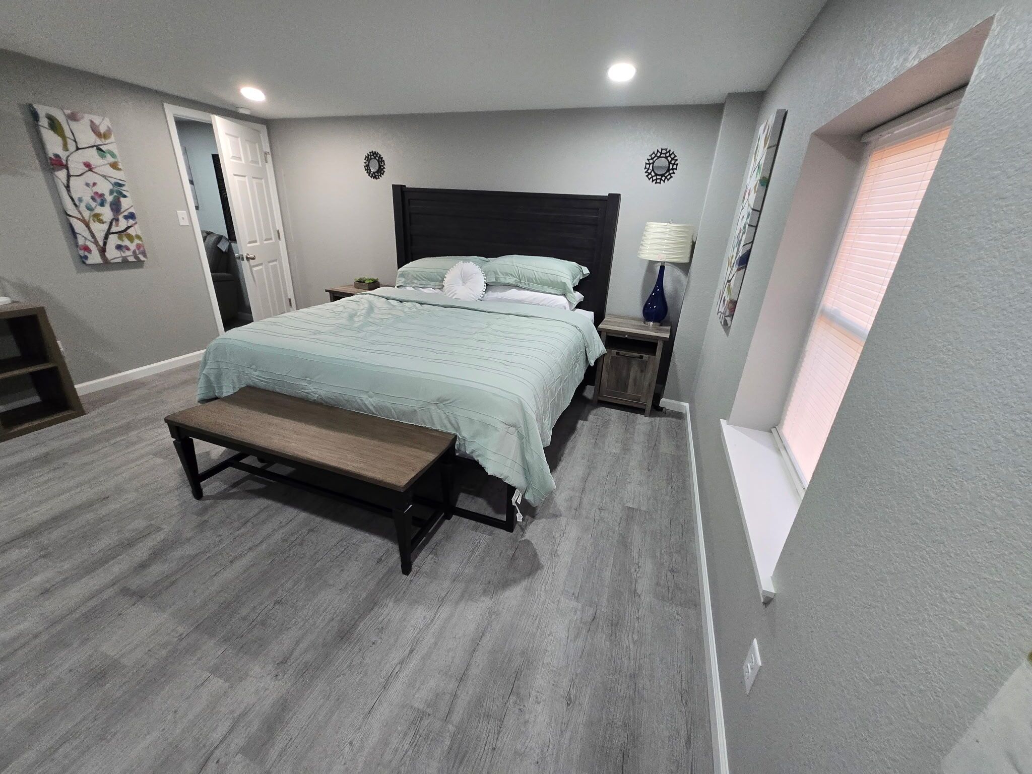 Una camera da letto con un letto, una panca, un comodino e una finestra.