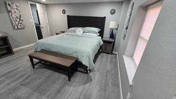 Una camera da letto con un letto, una panca, un comodino e una finestra.