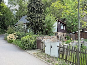 A house with a stone exterior, a wooden fence, and a paved driveway. - Welcome to the Waldhaus zur Kleinbahn! (Dippoldiswalde)