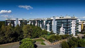 A modern apartment complex with multiple high-rise buildings, surrounded by greenery and a clear blue sky. - Comfortable Flat With Shared Pool (San Michele al Tagliamento)