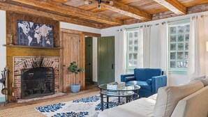 A cozy living room with a brick fireplace, a blue sofa, and a white couch. - Spacious Farmhouse Near the Beach Circa 1860 (Biddeford)