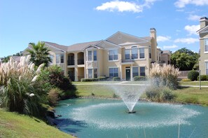 A multi-story residential building with a central courtyard featuring a fountain.