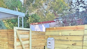 A wooden gate with a mailbox, a stone pathway, and a wooden fence. - Charming Home on Porter Avenue! (Biloxi)