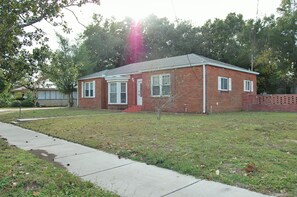 A single-story brick house with a front yard, a sidewalk, and a small tree. - Charming Home on Porter Avenue! (Biloxi)