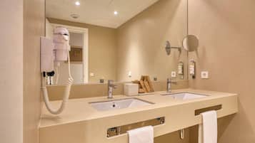 Casa de banho com duas pias, secador de cabelo e espelho.