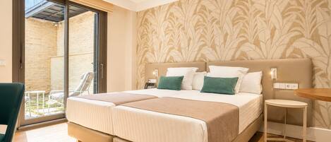 A double bed with a headboard, a bedside table, a chair, and a view of an outdoor patio.