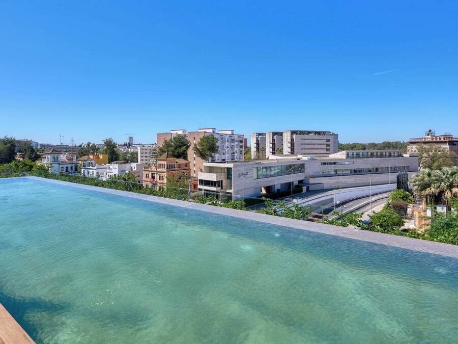 A swimming pool with a view of modern buildings and greenery.