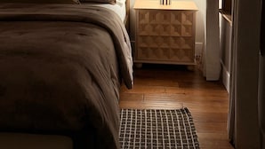 A bedroom with a bed, bedside table, lamp, and a framed picture on the wall. - River Place -Walk to Jefferson Methodist, 2BR Queen Beds 1 Bath -Patio & Grill (Philadelphia)