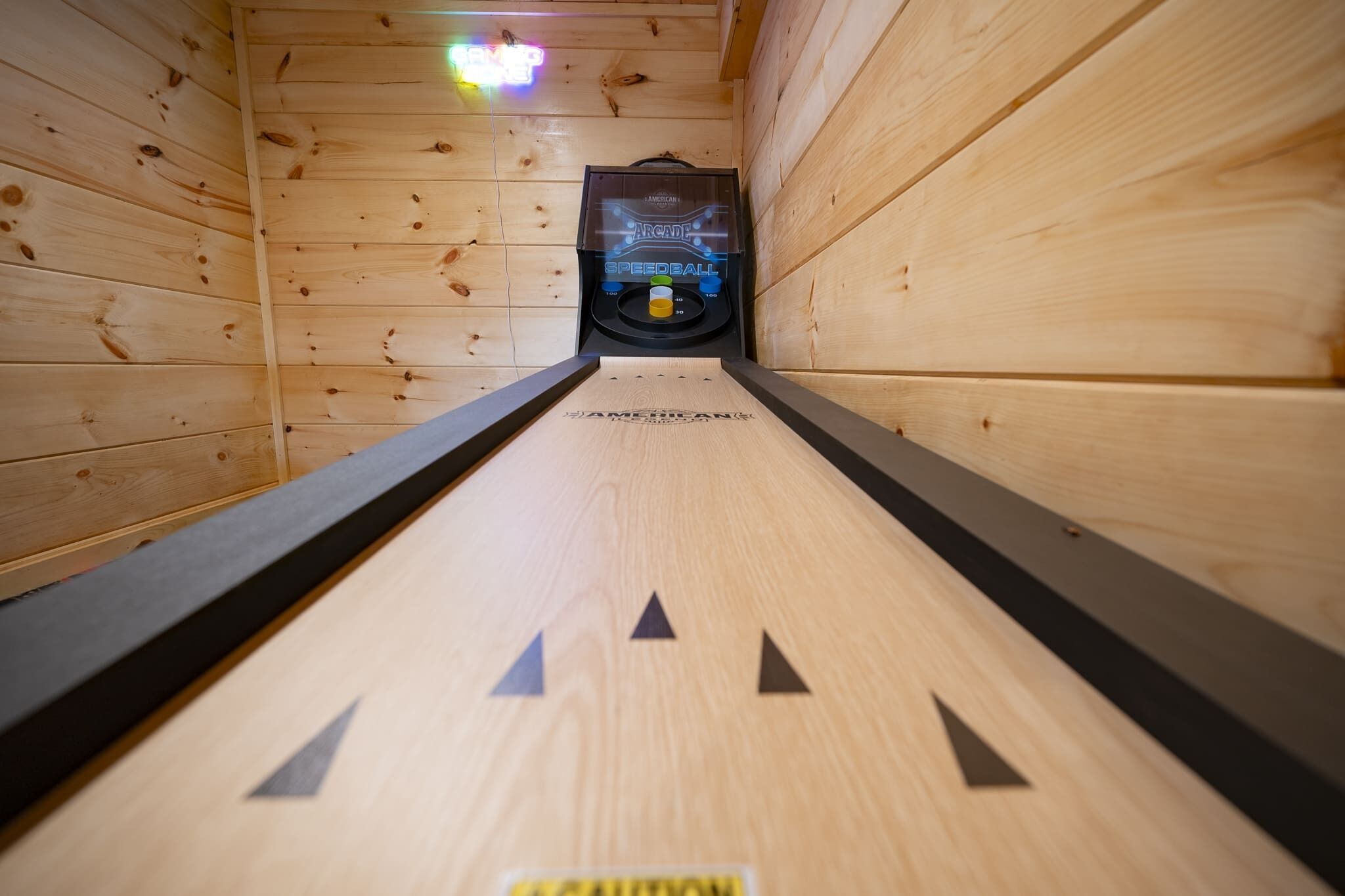 Una bolera de madera con máquina de velocidad y una pista de madera.